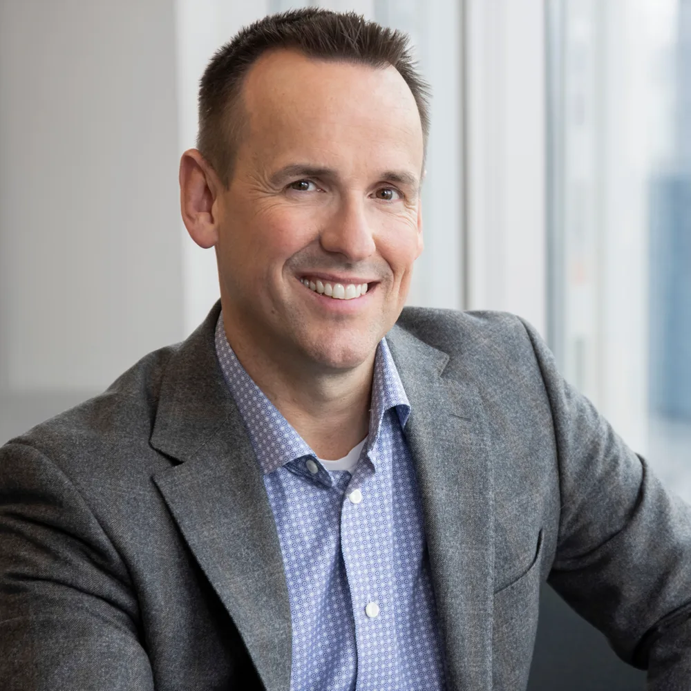Portrait of Craig Skeates by a window with natural light.