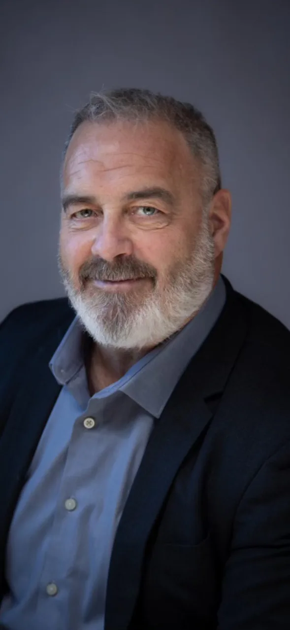 Professional headshot of Frank Langenhoff against a plain gray background.