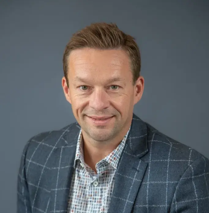 Professional headshot of Mike Kenyon against a plain gray background.