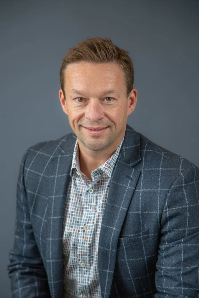 Professional headshot of Mike Kenyon against a plain gray background.